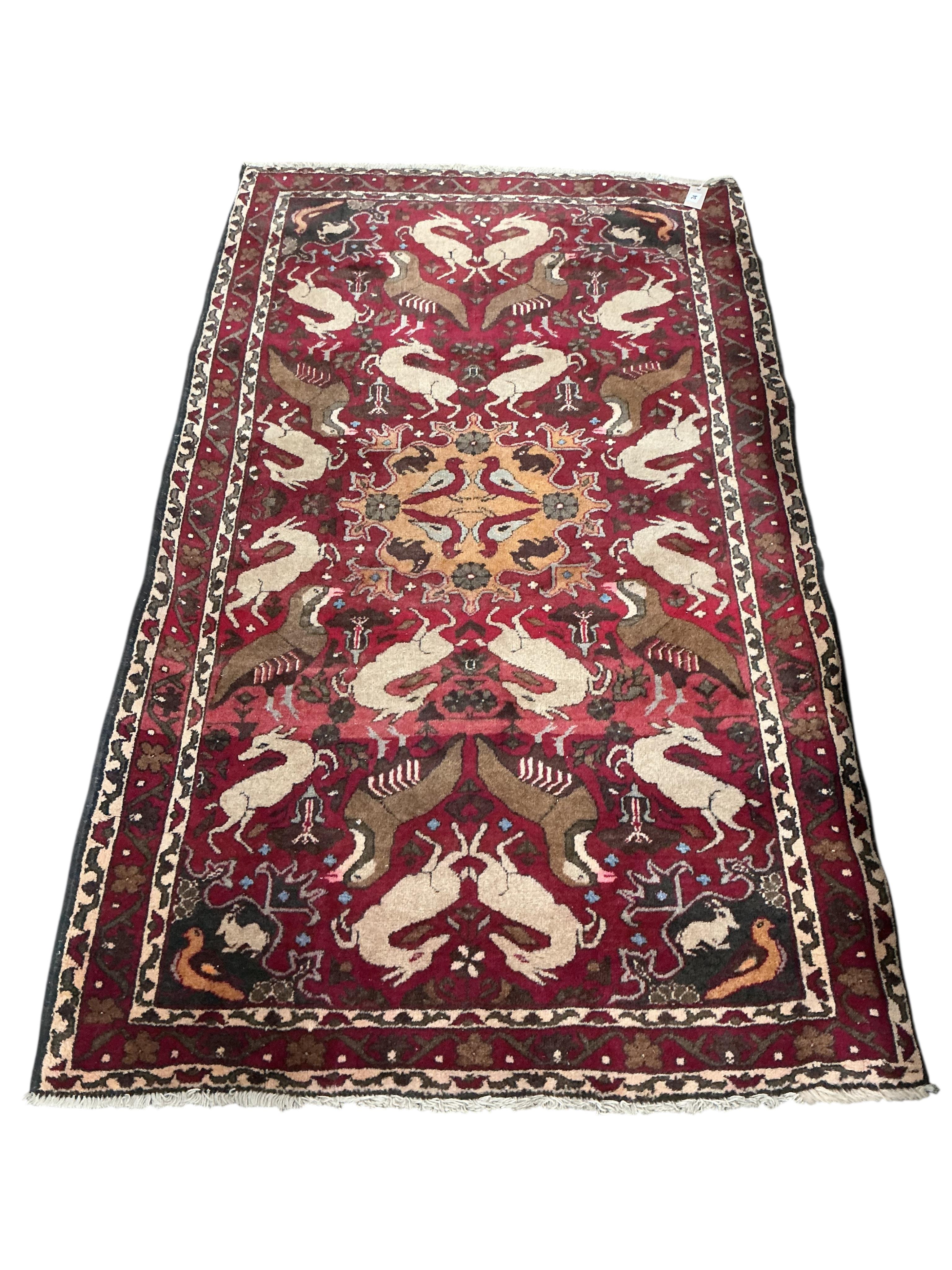 A North West Persian red ground pictorial rug, 180 x 104cm